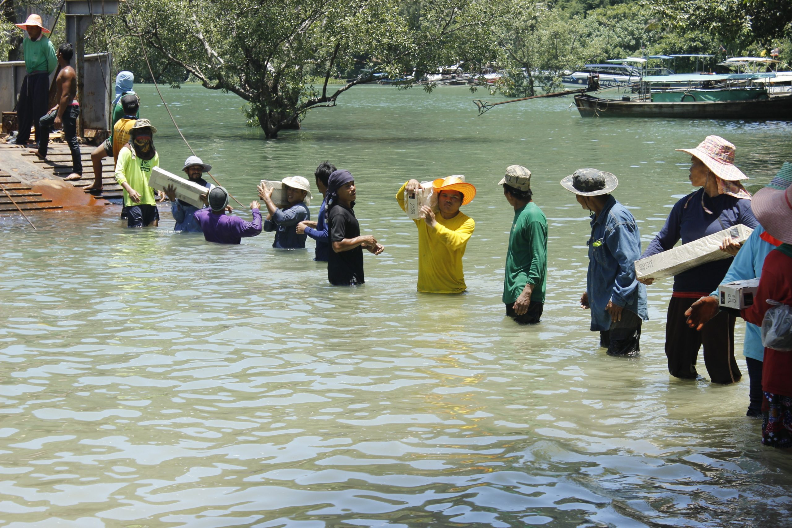 People stand in line in river after flooding in Thailand passing possessions from hand to hand